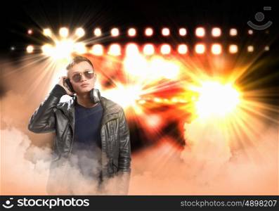 Rock musician wearing headphones. Image of young man rock musician at concert