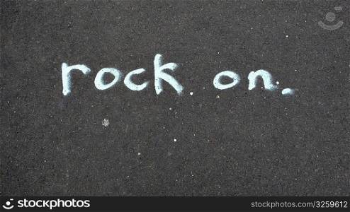 Rock On, written in chalk on sidewalk.