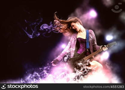 Rock passionate girl with black wings. Young attractive rock girl playing the electric guitar