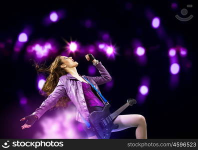 Rock passionate girl with black wings. Young attractive rock girl playing the electric guitar