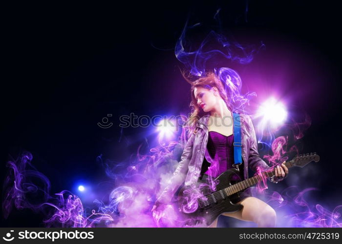 Rock passionate girl with black wings. Young attractive rock girl playing the electric guitar