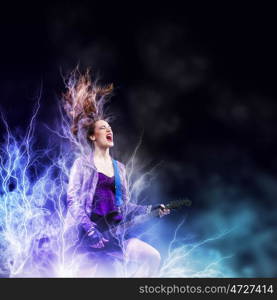 Rock passionate girl with black wings. Young attractive rock girl playing the electric guitar