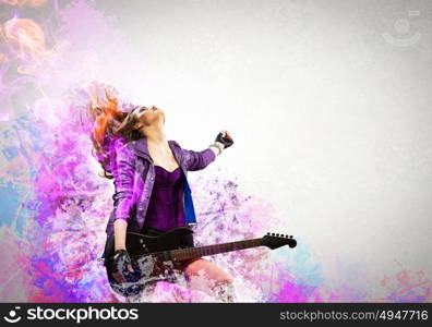 Rock passionate girl with black wings. Young attractive rock girl playing the electric guitar