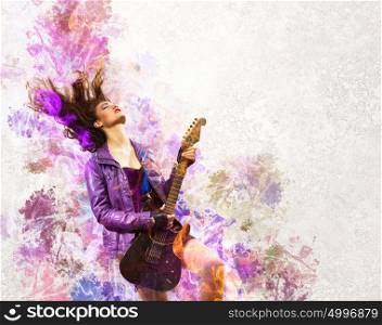 Rock passionate girl with black wings. Young attractive rock girl playing the electric guitar