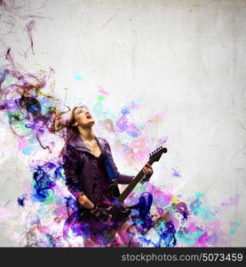 Rock passionate girl with black wings. Young attractive rock girl playing the electric guitar