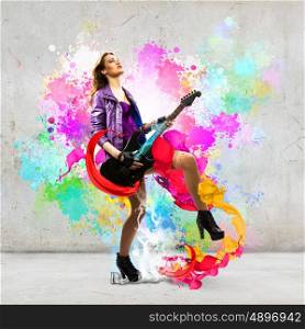 Rock passionate girl. Young attractive rock girl playing the electric guitar