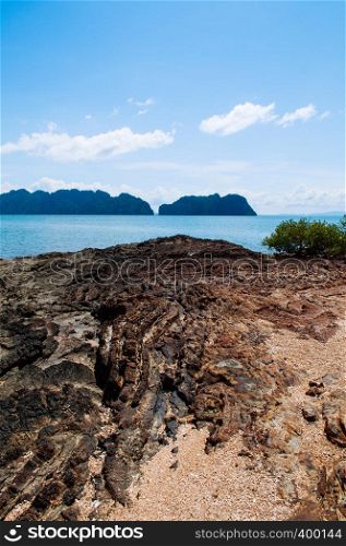 Rock sand beach on small island near Koh Lanta with Koh Talabeng island in background. Krabi - Thailand