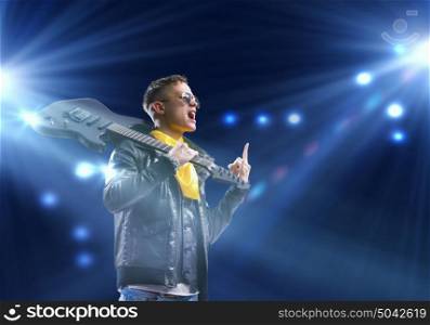 Rock star. Young man, rock musician in jacket with guitar
