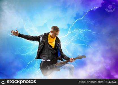 Rock star. Young man, rock musician in jacket with guitar