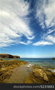 rock stone sky cloud beach water coastline and summer in lanzarote spain