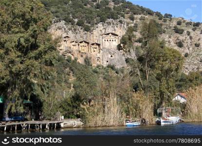 Rock tombs and river with boats in Dalyan, Turkey