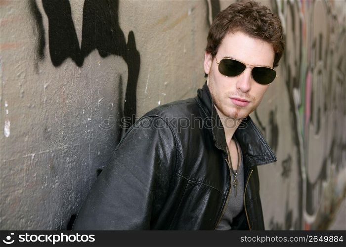 rocker rock star young man sunglasses on silver wall city outdoor