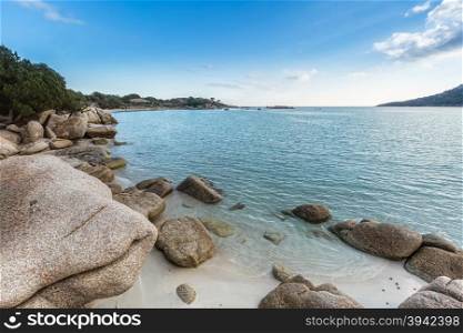 Rocks and boulders in a translucent turquoise sea and blue skies at Santa Giulia beach in Corsica