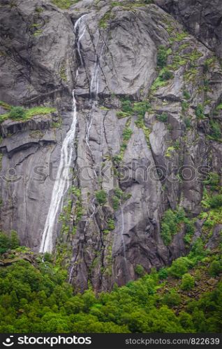 Rocks and stones cliffs with waterfall surrounded with green moss. Background with nature details concept.. Rocks and stones cliffs with waterfall