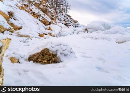Rocks in Lake Baikal covered with ice and snow, Russia