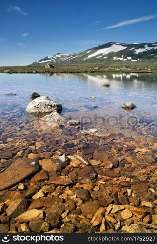 Rocks in lake Sjodalsvatnet in the Norwegian region Valdres. Rocks in lake Sjodalsvatnet