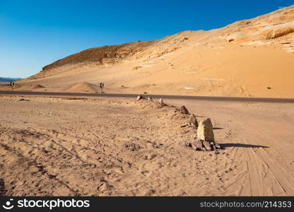 Rocks in sand desert in sunny evening