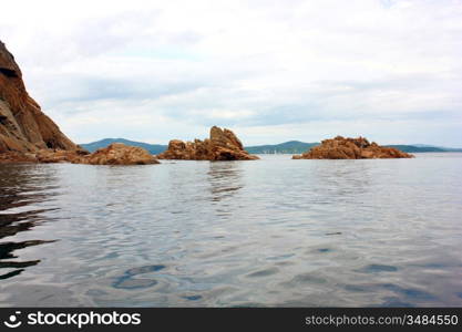 Rocks in the blue sea, illuminated by the sun. Background.