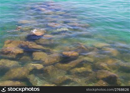 Rocks in the crystal clear waters of a Normandy beach