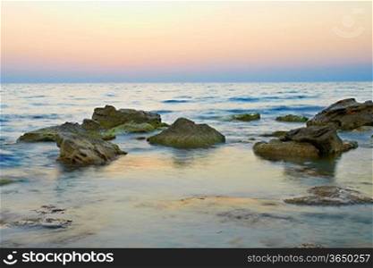 Rocks in the sea against beautiful sunset
