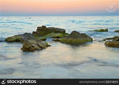 Rocks in the sea against beautiful sunset