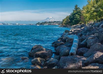 Rocks line the shore in Ruston, Washington. Mount Rainier can be seen in the distance.