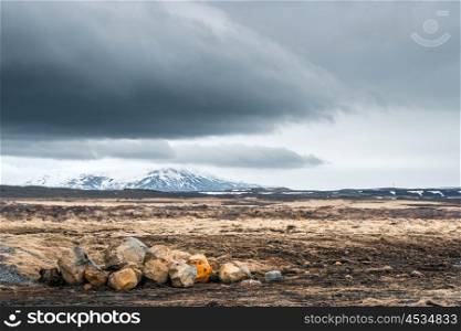 Rocks on a field with mountains in cloudy weather