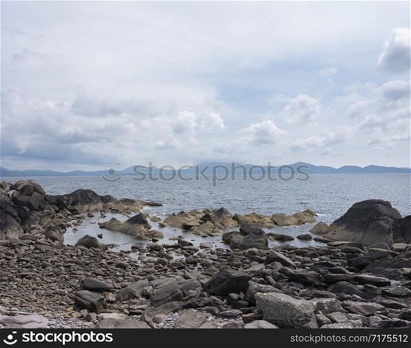 rocks on coast of kerry in west ireland with beara in the background
