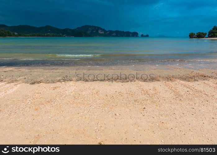 rocks on the horizon in the sea, beautiful scenery. In the foreground there is a sandy beach