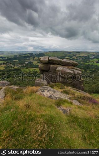 Rocks piled up on the edge of a hill at Froggatt Edge in the Peak District, Derbyshire