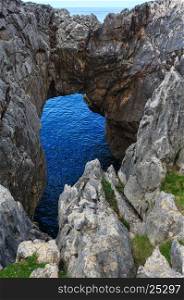 Rocky arch near shore. Coast view, Asturias, near Camango, Spain.