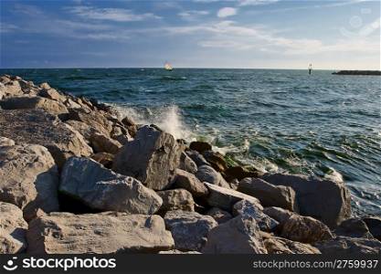 rocky beach with yacht on the horizon. Destin, Florida, USA