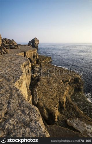 Rocky cliff landscape with sunset over ocean