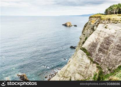 Rocky cliffs landscape at Asturias coast in north Spain. View from Faro de Cabo Busto. Tourist attraction, place to visit.. Asturias coast. Cabo Busto cliffs, Spain.