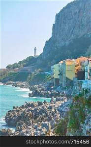 Rocky coast in Cefalu and lighthouse, Sicily, Italy