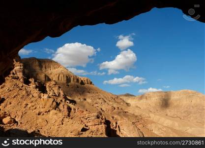 Rocky desert landscape seen through the cave entrance