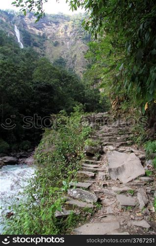 Rocky footpath, river a nd waterfall in Nepal