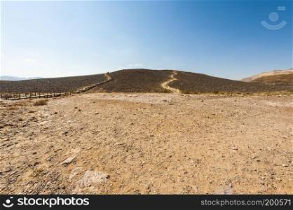 Rocky hills of the Negev Desert in Israel. Breathtaking landscape of the rock formations in the Southern Israel. Dusty mountains interrupted by wadis  and deep craters.