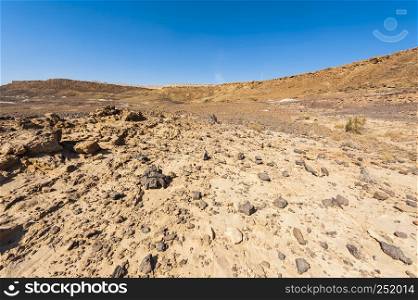 Rocky hills of the Negev Desert in Israel. Breathtaking landscape of the rock formations in the Southern Israel. Dusty mountains interrupted by wadis and deep craters.