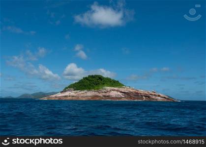 Rocky island with sea on the horizon and blue sky. Booby rock Island, Praslin, Seychelles