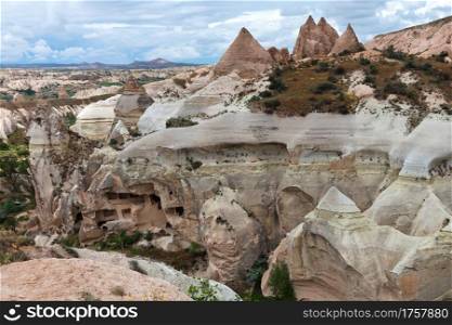 Rocky mountain ranges of Cappadocia of red and white sandstone, ancient caves in the mountain landscape of central Turkey.. Ancient caves in the rocky mountain ranges of Cappadocia, an unusual landscape of central Turkey.