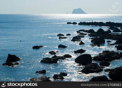 Rocky seashore with sun light reflect in the morning