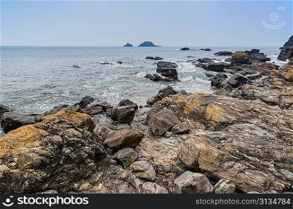 Rocky shore and Brisons Rock in distance at Cape Cornwall