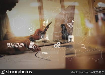 ROI Return on Investment indicator in virtual dashboard for improving business. business man hand working on laptop computer with digital layer business graph information diagram on wooden desk as concept