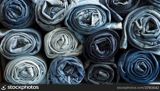 Roll blue denim jeans arranged in stack