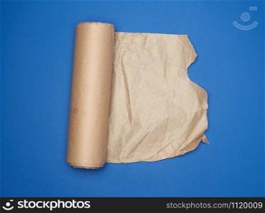 roll of brown parchment paper on a blue background, copy space, top view