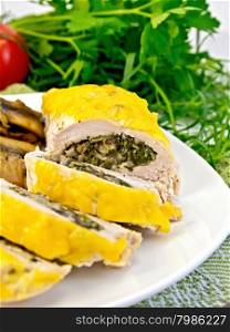 Roll of chicken breast with spinach, mushrooms and cheese in a white plate with fried mushrooms on a green napkin, tomatoes, dill on a wooden boards background