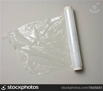 roll of transparent cling film for packaging ona gray background, top view