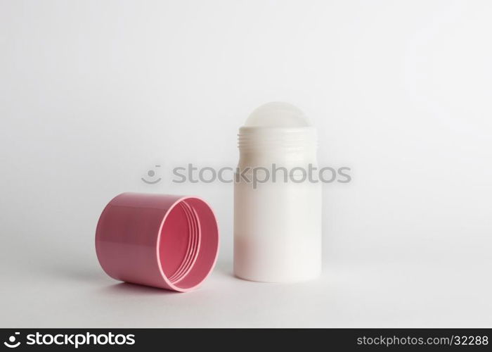 Roll-on antiperspirant cosmetic and pink cover isolated on white background. Roll-on antiperspirant isolated white background