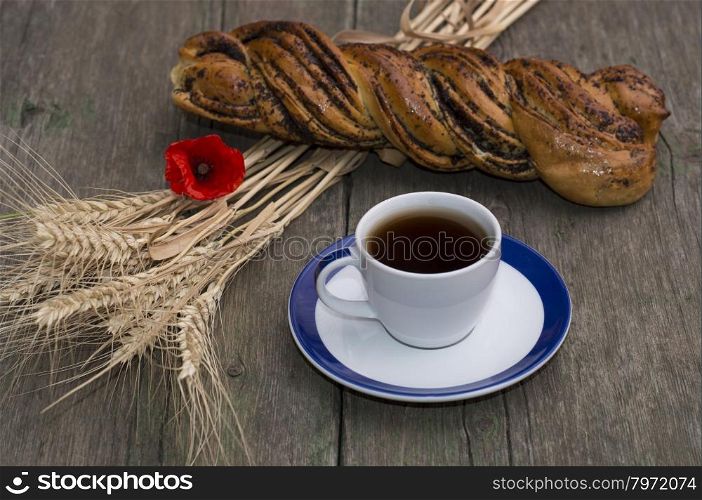 roll, wheat ears, flower of poppy and coffee, still life on a subject drinks and food